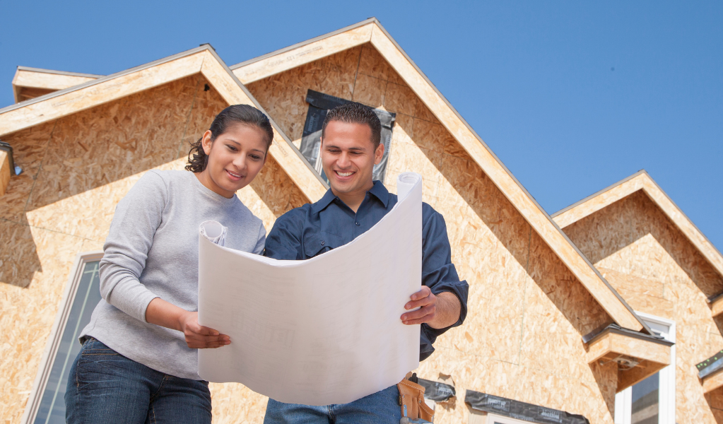 Couple with new build Couple in front of new built home